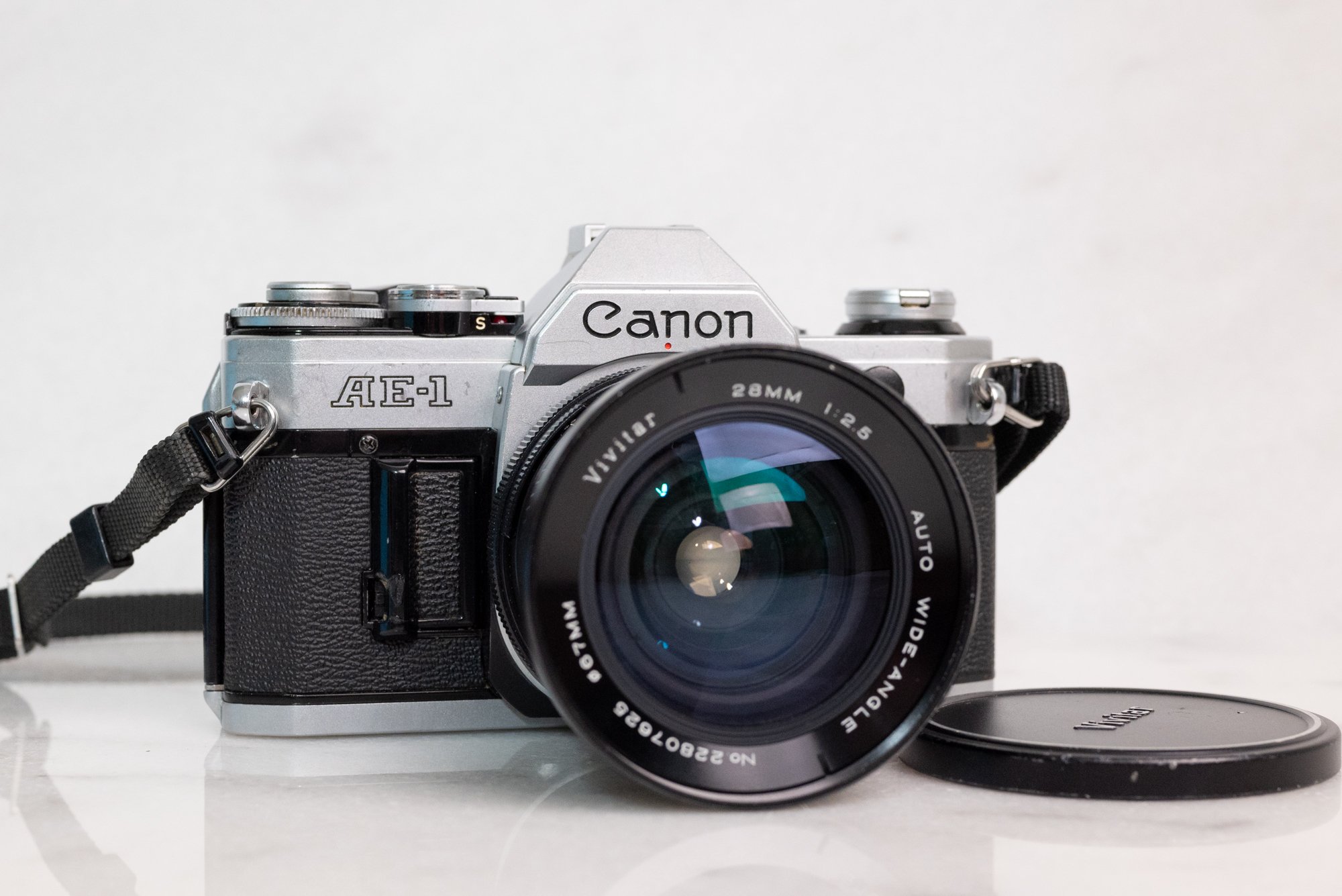 Canon AE-1 35mm Film SLR Camera with Canon FD 50mm F/1.8 Fast Prime Lens,  Cap, Strap and Battery — F Stop Cameras